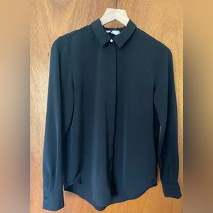 Black satin blouse, gold top button.